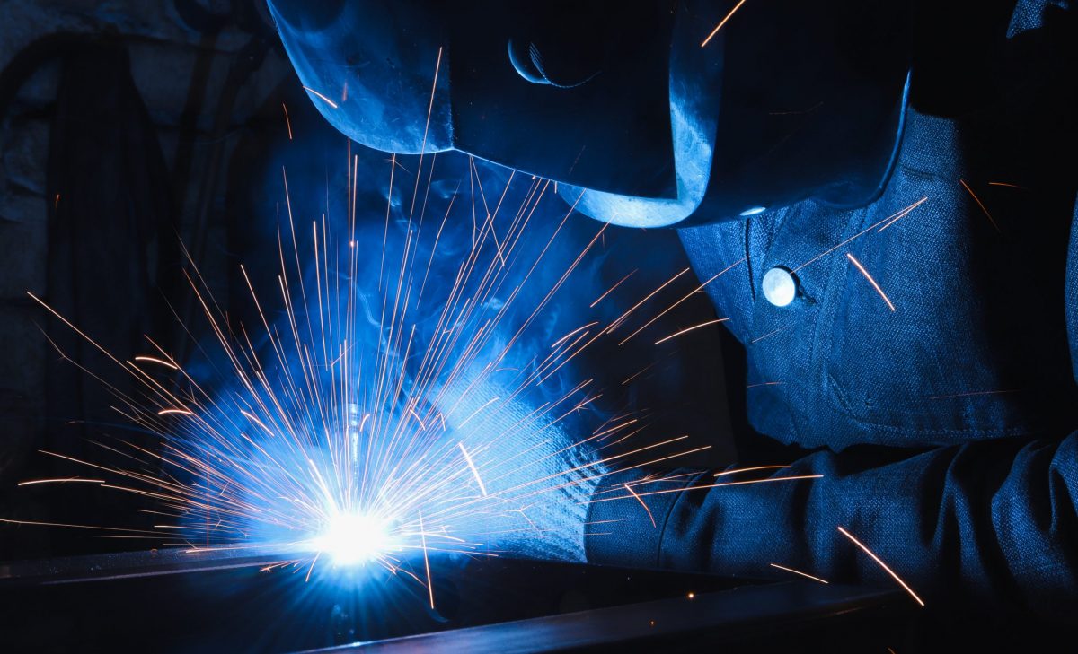 factory welder welds parts with a semi-automatic welding machine